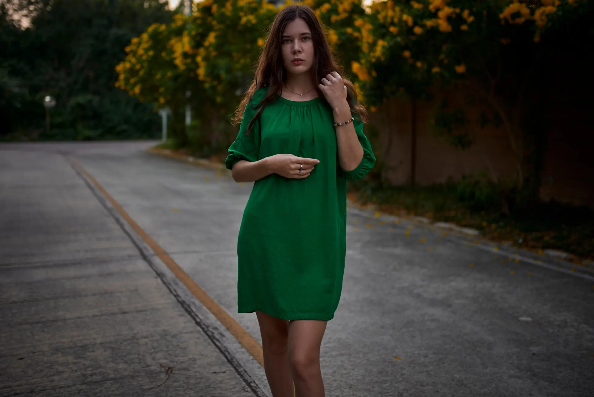 Nana standing on a path in a green dress