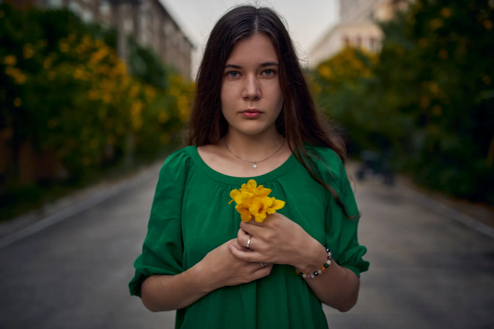Nana holding yellow flowers, wearing a green dress