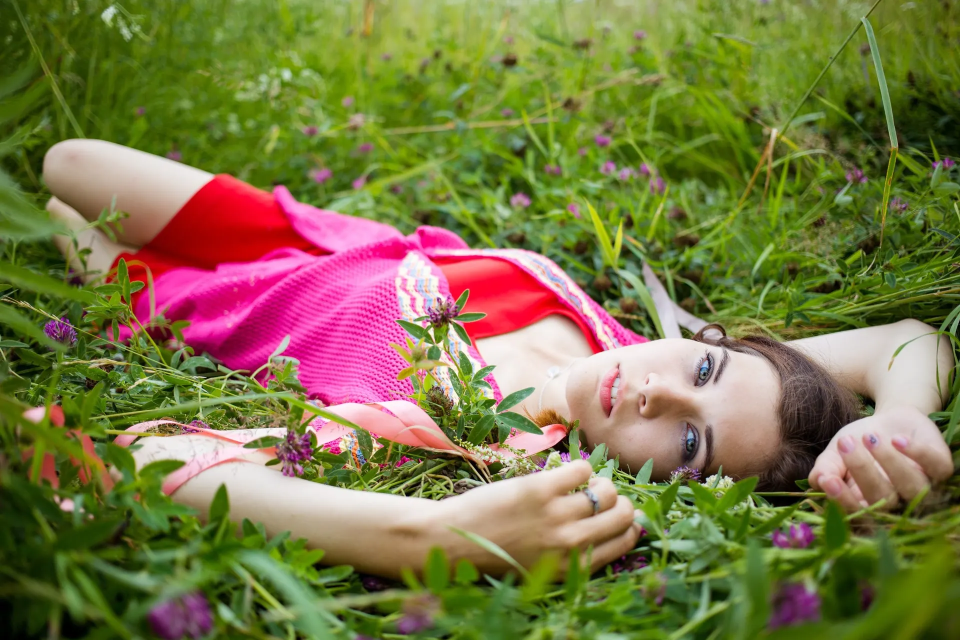 Nana reclining in the grass in a pink dress