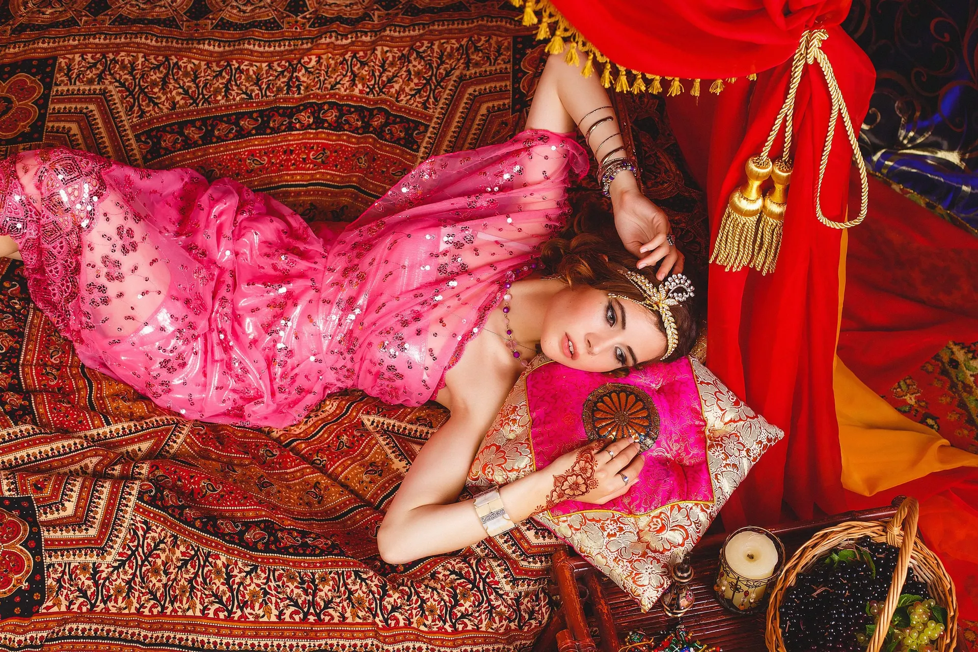 Nana in a pink dress reclining in a richly decorated interior