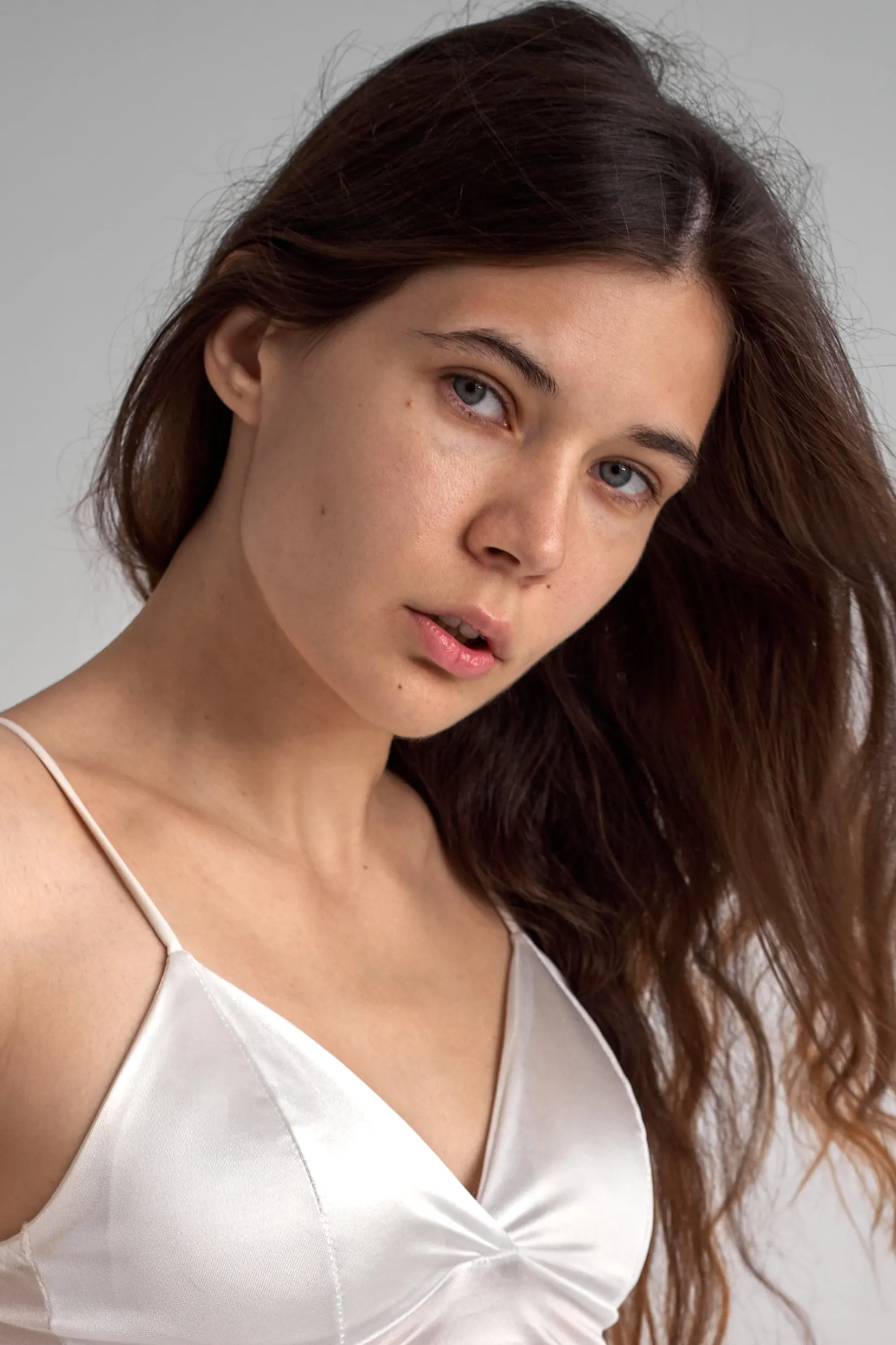 Nana in a white satin top, close-up studio portrait