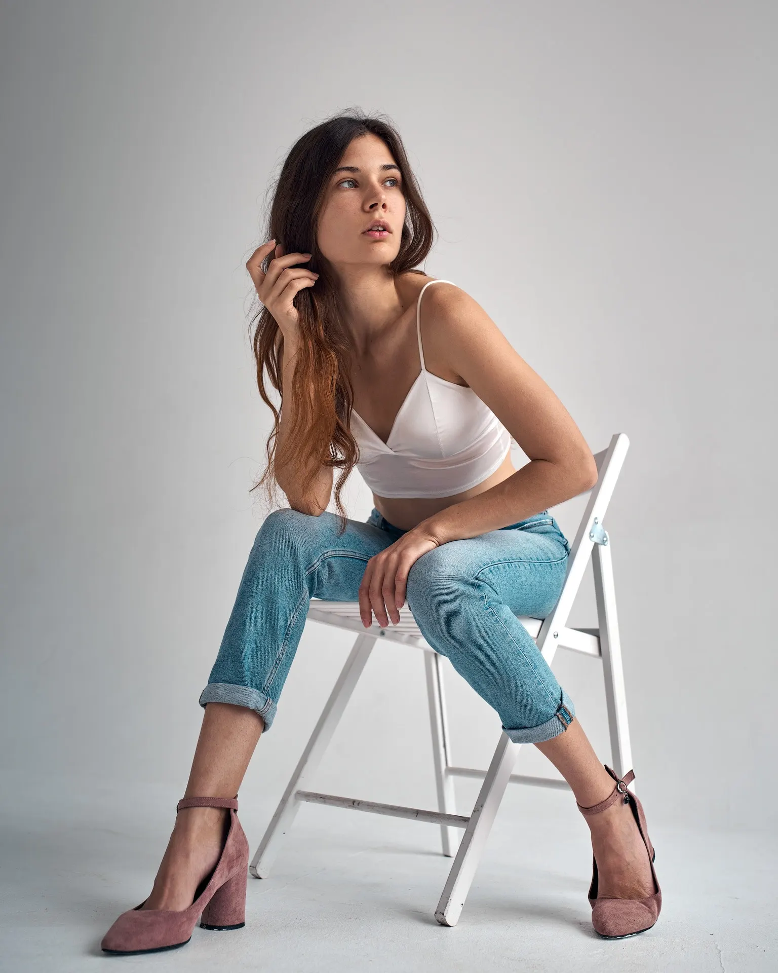 Nana leaning forward on a chair in a studio